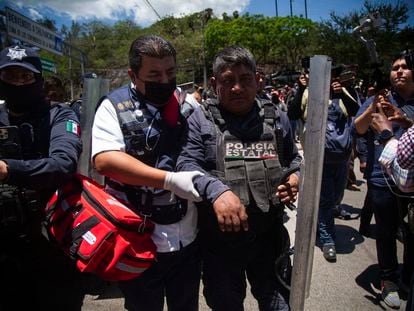 Uno de los policías retenidos es apoyado por un paramédico tras ser liberado por los manifestantes, el 11 de julio en Chilpancingo (Guerrero).
