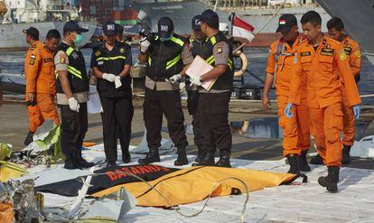 Miembros de los equipos de rescate, al lado de una víctima del accidente de Lion Air, este viernes en Yakarta.