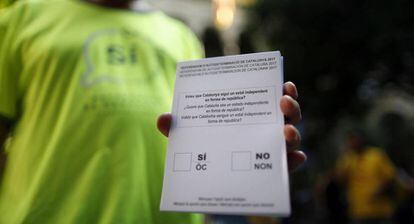Una persona muestra una de las papeletas del refer&eacute;ndum sobre la independencia de Catalu&ntilde;a.