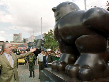 Colombian artist Fernando Botero presents a new sculpture of "The Bird" to replace an identical sculpture, background, that was destroyed by a bomb which killed 22 people in 1995, in Medellin on Wednesday, Jan. 5, 2000. Botero placed the new sculpture next to the remains of the original as a symbol of peace. (AP Photo)