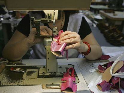 Una mujer cose unas sandalias en una fábrica de calzados en Monóvar (Alicante).