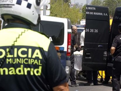 Dos policías observan el traslado de la mujer fallecida.