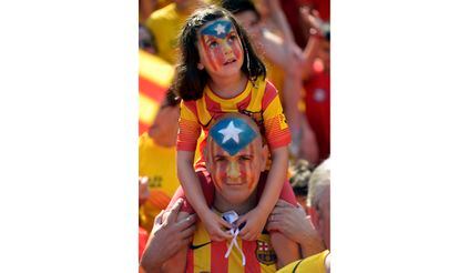 Un padre y su hija, con la cara pintada de los colores de la bandera estelada, durante la celebración de la Diada en Barcelona.