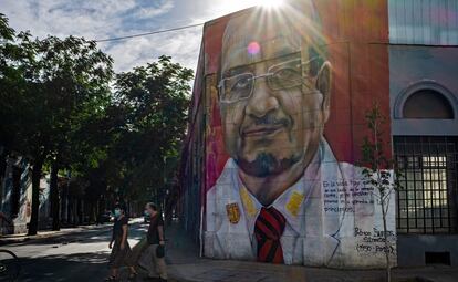 La gente pasa frente a un mural en el barrio de Yungay.