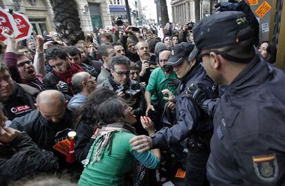 Forcejeo de piquetes con policías ante la sede del Banco de España en Valencia.