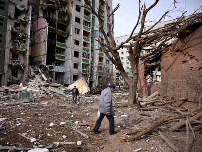 Dos hombres pasan frente a un edificio residencial dañado en el bombardeo de la ciudad de Chernihiv, este viernes.