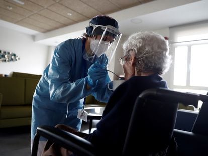 Una cuidadora ayuda a comer a una anciana en la residencia Casablanca, en el barrio madrileño de Villaverde.