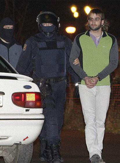 Agentes del Cuerpo Nacional de Policía trasladan a uno de las ocho detenidos esta madrugada en Vizcaya por violencia callejera.