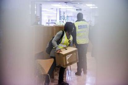 Una policía transporta una caja en el registro a unas dependencias del Ayuntamiento de Sabadell.