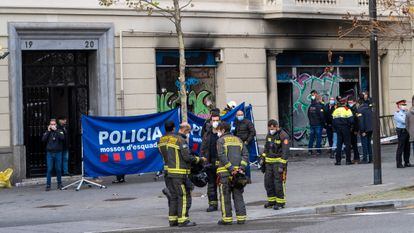 Un grupo de bomberos conversa delante de la oficina bancaria ocupada en la plaza Tetúan cuyo incendio causó cuatro víctimas mortales.