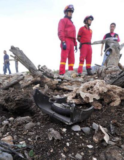 Los servicios de rescate observan los restos del avión.