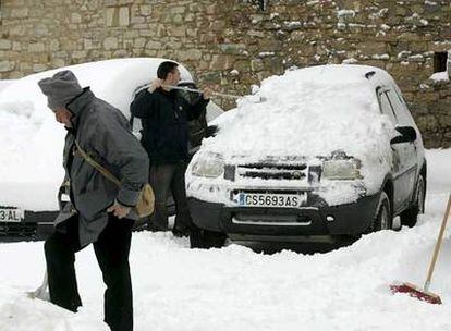 Un vecino de Ares (Castellón) quita la nieve de su vehículo.