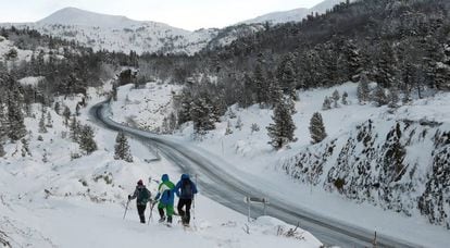 Varias personas con raquetas de nieve comienzan una pequeña travesía por el pirineo navarro, en la zona de Larra-Belagua, este domingo.
