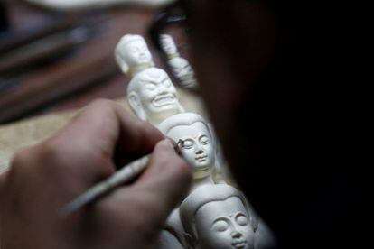 Un hombre talla una pieza de marfil en un taller en Pekín (China).