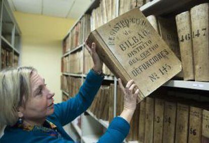 Una empleada muestra los libros del archivo del Registro Civil de Bilbao.