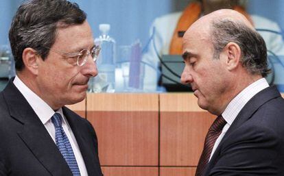 Mario Draghi conversa con Luis de Guindos durante la reuni&oacute;n de los ministros de Finanzas del euro.