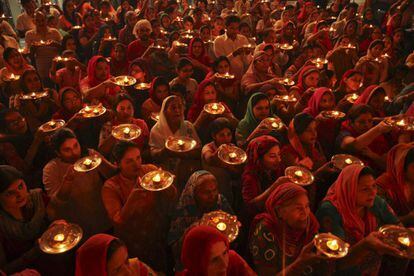 Devotos hindús sujetan lámparas de aceite en el interior de un templo durante el festival Navratri celebrado en Chandigarh (India).