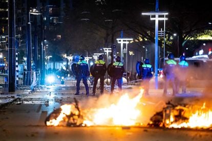 Police officers face protesters on a street in Rotterdam on Saturday night. 
