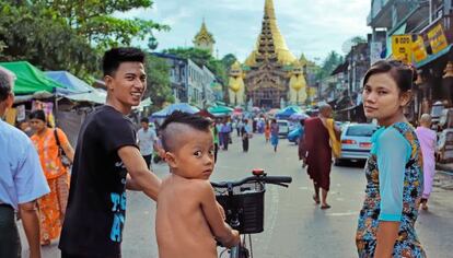 Una pareja y su hijo en una de las calles que dan paso a una de las entradas del complejo religioso de Shwedagon, uno de los centros budistas más importantes de la antigua capital de Myanmar.