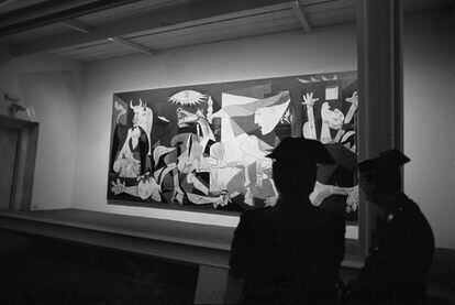 Agentes de la Guardia Civil vigilan la urna blindada que protege el 'Guernica', obra de Pablo Picasso, en su presentación en el emplazamiento del Casón del Buen Retiro de Madrid, tras su regreso a España.