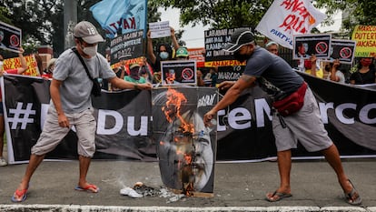 Activistas filipinos queman un cartel con la imagen de los candidatos electorales Sara Duterte y Ferdinand Marcos Jr durante una protesta