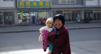 Una mujer con un beb&eacute; en Tangshan, en el norte de China.