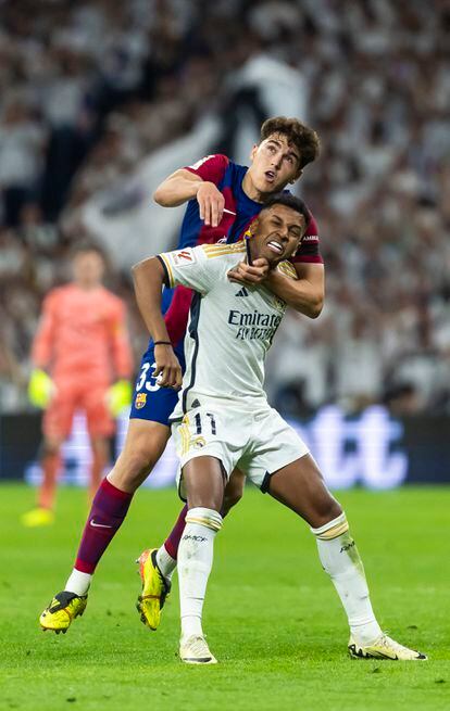 Cubarsi, from FC Barcelona, ​​tries to stop Rodrygo, from Real Marid, from controlling the ball in a play.