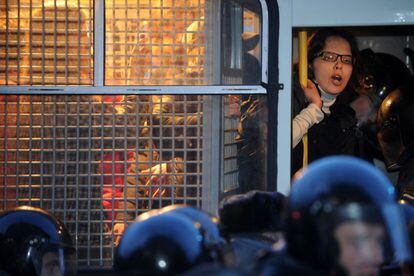 Una activista de Otra Rusia lanza gritos contra Putin desde un furgón policial.
