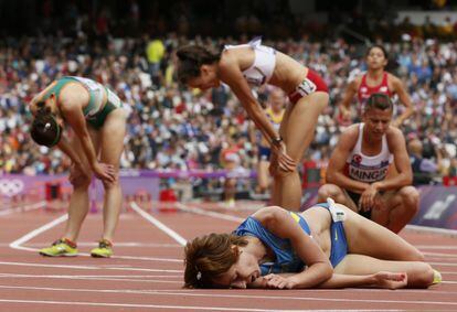 La ucraniana Valentyna Horpynych Zhudina (en el suelo) y otras atletas recobran el aliento tras la carrera de 3.000 metros obstáculos.