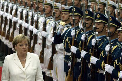 Angela Merkel pasa revista a la guardia de honor en el gran salón popular, ayer en Pekín.