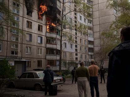 Unos vecinos observaban los daños en un edificio tras un ataque ruso, este lunes en Járkov.