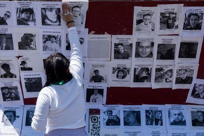 Una activista coloca imágenes de agresores sexuales durante una protesta en el Zócalo capitalino, el 8 de marzo de 2022.