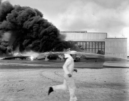 Un marinero estadounidense corre frente a un avión destruido en la base Hickam (Hawái), el 7 de diciembre de 1941.