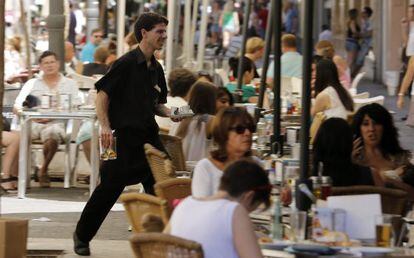 Un camarero trabaja en una terraza del centro de Valencia