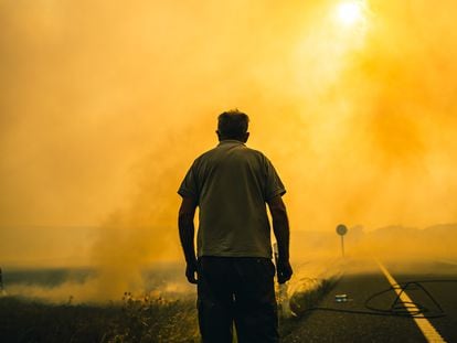 Un hombre mira las llamas del incendio forestal de Sierra de la Culebra, en Zamora, el pasado 19 de junio.