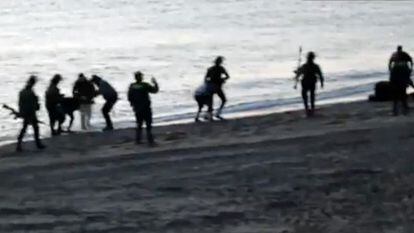 Varios guardias civiles devuelven inmigrantes a Marruecos desde la playa de Tarajal, el día 6.