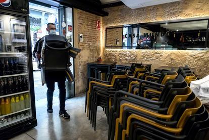El propietario de un bar de Valencia recoge las sillas de la terraza el 18 de enero.