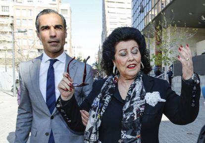 La exdirectora del IVAM, Consuelo Ciscar, junto a su abogado, pide a los medios de comunicaci&oacute;n que le dejen pasar, a la salida de los juzgados en Valencia esta ma&ntilde;ana. 