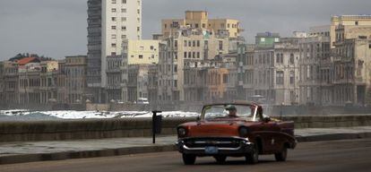 Un viejo auto circula por el malec&oacute;n La Habana. 