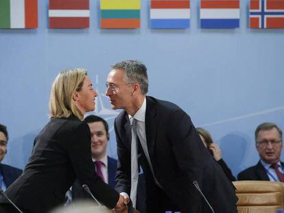 Federica Mogherini y Jens Stoltenberg se saludan en la reunión de ministros de Defensa.