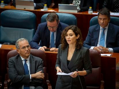 La presidenta de la Comunidad de Madrid, Isabel Díaz Ayuso (de pie), junto al vicepresidente, Enrique Ossorio, en el pleno de la Asamblea de Madrid, este jueves.