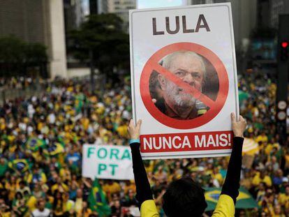 Un seguidor de Bolsonaro con un cartel contra Lula, el pasado domingo en São Paulo. En vídeo, Brasil vota en unas elecciones cruciales.