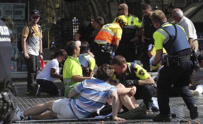 Agentes de policía, sanitarios y transeúntes atienden a los heridos en el atentado terrorista yihadista de La Rambla de Barcelona en 2017.