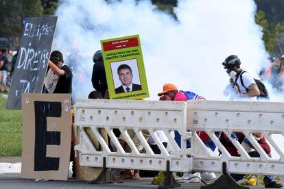 Los protestantes se cubren la cara con máscaras para evitar el gas lacrimógeno.