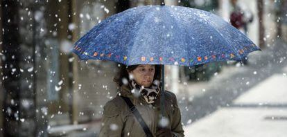 Una mujer camina este miércoles por Vitoria bajo los copos de nieve. 