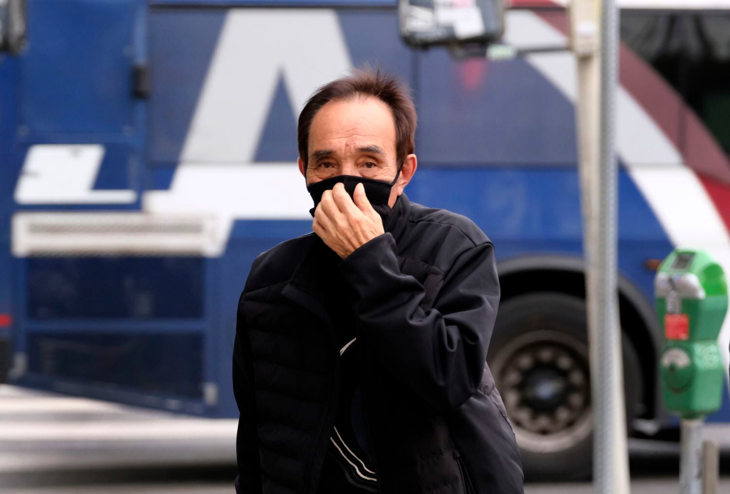 Un hombre se cubre la cara en el barrio de Koreatown, en Los Ángeles.