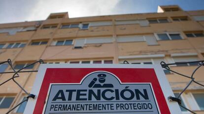 Unos pisos vacíos en Ibiza, con una señal de seguridad advirtiendo de que están protegidos.