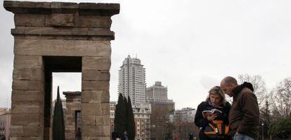 Una pareja de turistas j&oacute;venes consulta la gu&iacute;a frente al Templo de Debod de Madrid