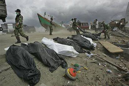 Soldados indonesios apilan los cuerpos rescatados de un río en el centro de Aceh.