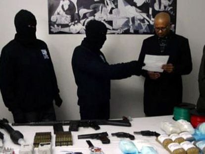 Dos encapuchados de ETA muestran un inventario de armas y explosivos a dos miembros de la Comisi&oacute;n de Verificaci&oacute;n el pasado 21 de febrero. 
